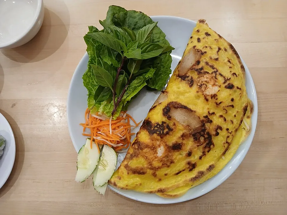 Gele bánh xèo-pannenkoek met vulling en garnituren