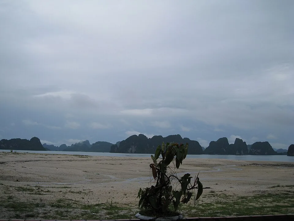 Breed zandstrand met heuvels op de achtergrond op Quan Lạn